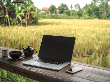 Laptop ve kahve fincanı açık masada.