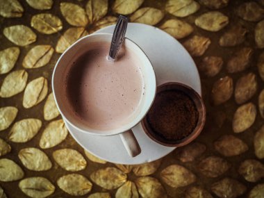 Kahve fincanı ve sıcak çikolata masanın üstünde.