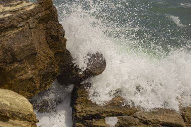 Günlük tarafından büyük kayalar sandviç olduğunu. Dalgalar bir fırtına sırasında. Yukarıdan görüntüleyin. Kırmızı kod. Bulgaristan'ın Karadeniz kıyısında bekletin. Elemental kuvvet. Dalgalar kayalar karşı çökmesini.