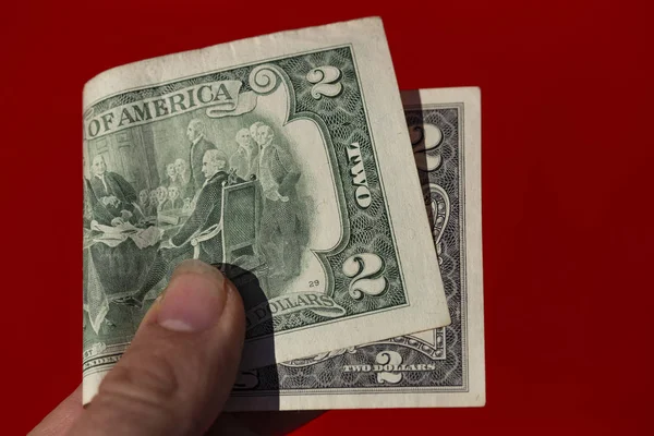 Ein Zwei Dollar Schein Der Hand Eines Mannes Vor Rotem — Stockfoto