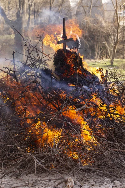 Flaming fire. Burning tree branches. Pagan rite dedicated to the arrival of spring. Big bonfire on Shrovetide.