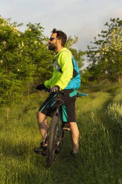 Bisikletçi MTB üzerinde sürmek. Freerider bir buğday tarlası aracılığıyla off-road sürmek. Eğitimdeki atlet. Agresif spor. Aşırı rekreasyon.