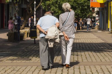 Şehir sakinlerinin hayatları. Yürüyen yaşlı bir çift. Büyükbaba ve büyükanne şehir caddesi boyunca yürüyorlar..