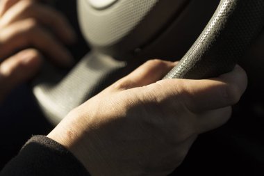 Kızın eli trafik sırasında arabanın direksiyonunu tutuyor. Kadın bir sürücü..