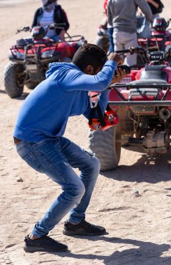 Komik Arap fotoğrafçı. Sahra Çölü 'ndeki bir Safari sırasında turistlerin fotoğraflarını çekmek.