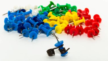 Kağıtları tutturmak için keskin bir iğne. Sosyal anlamsal Birlik-engelleyici, pranga, sıkma. Renkli kırtasiye düğmeleri açık arkaplanda serili. Eğitim için karanfiller. Kağıt ekleniyor.