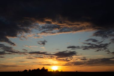 Gün batımında destansı manzara. Trajik kasvetli gökyüzü. Dünya gezegenindeki muhteşem gökyüzü. Kıpkırmızı bir alacakaranlık. Panorama.