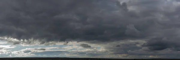 暴风雨的云彩覆盖了整个风景 凄惨阴郁的天空 草原上的村庄地球上奇妙的天空 — 图库照片