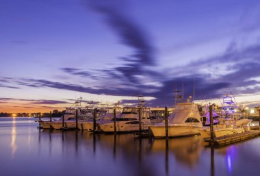Yavaş çekim hızı kullanarak Belmar Marina, New Jersey, üzerinde at gündoğumu featuring dramatik gökyüzü arka plan ve ön plan gemilerde vurdu