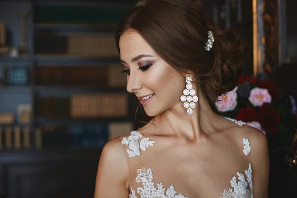 Retrato de menina modelo morena bonita e elegante com maquiagem profissional brilhante e brinco elegante, preparação de casamento da jovem noiva — Fotografia de Stock