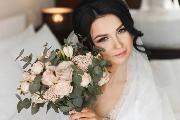 Retrato de menina modelo morena bonita e sexy com maquiagem profissional brilhante e com buquê de flores de rosa em suas mãos — Fotografia de Stock