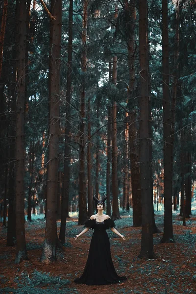 Menina modelo morena elegante e na moda à imagem de Maléfica posando entre a floresta mística - história de conto de fadas, cosplay — Fotografia de Stock