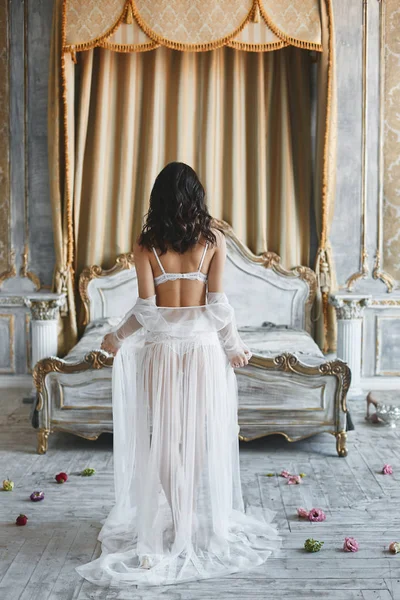 Полуобнаженная, сексуальная и красивая, брюнетка модель женщина в нижнем белье, стоит позади в спальне — стоковое фото