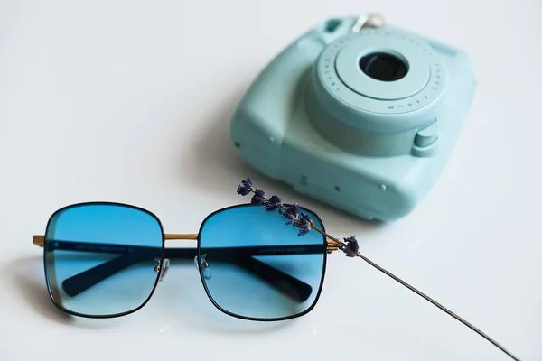时尚时尚太阳镜与蓝色镜头附近的小照片相机, 隔离在白色背景 — 图库照片