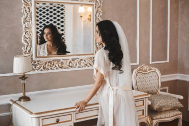 Güzel ve seksi esmer modeli kız moda sabahlığı klasik iç, onun yansımanın aynaya bakarak