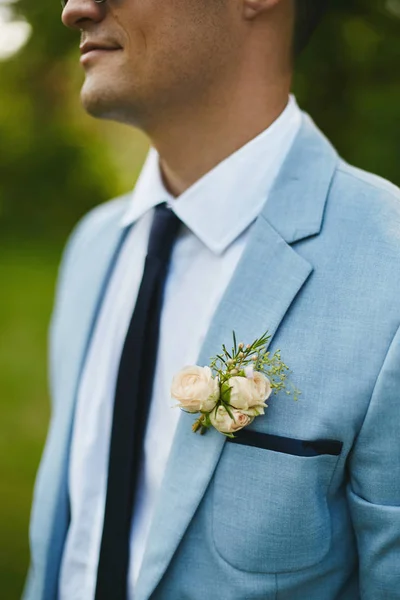 Boutonniere on a fashionable blue jacket of a stylish handsome young man — Stock Photo, Image