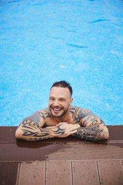 Yakışıklı genç acımasız bir adam, şık ve modaya gülümseyen adam Yüzme Havuzu Açık havada poz