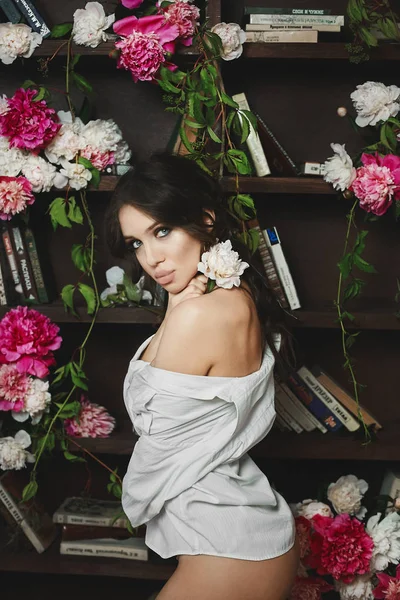 Bella e sexy giovane donna modello bruna con grandi labbra e occhi blu-verdi in posa mezza nuda in biblioteca — Foto Stock