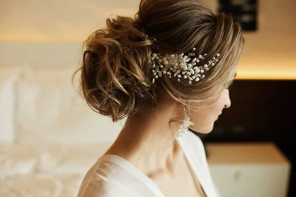 Penteado de casamento de menina modelo bonita e elegante de cabelos castanhos em um vestido de renda, com brincos e jóias em seu cabelo — Fotografia de Stock