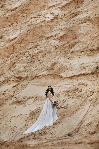 Menina modelo morena elegante e elegante com jóias na cabeça no vestido de renda na moda posando na colina arenosa — Fotografia de Stock