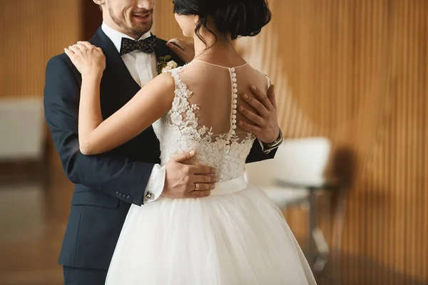 Couple de danse à la mode, beau jeune homme dans le costume élégant et belle fille modèle brune avec coiffure de mariage dans la robe en dentelle blanche — Photo