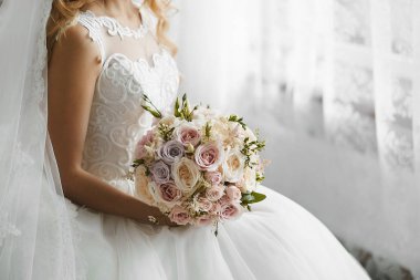 Bir gelinlik seksi güzellik elinde taze renkli çiçekler güzel bir düğün buketi