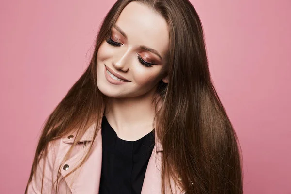 Retrato de incrível linda garota modelo loira com maquiagem profissional brilhante sexy e olhos fechados, em t-shirt preta e jaqueta de couro isolada em fundo rosa em estúdio — Fotografia de Stock