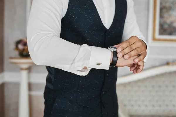 Vista cercana de los relojes de lujo en la mano de un hombre de negocios guapo en un esmoquin y en una camisa con gemelos — Foto de Stock