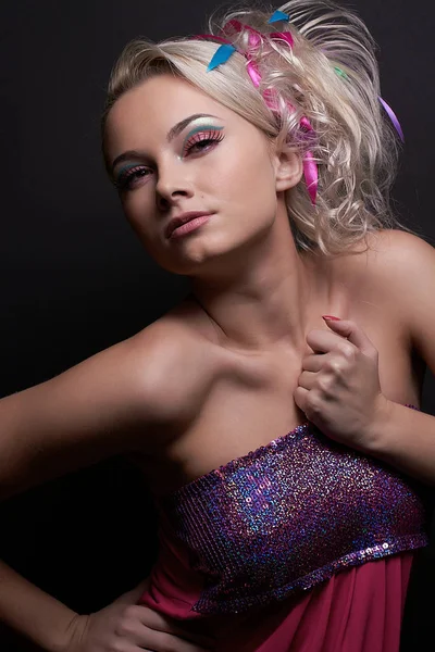 Vacker blond modell flicka med fashionabla ljusa makeup och med färgade band i hennes snygga frisyr, isolerad på svart bakgrund — Stockfoto