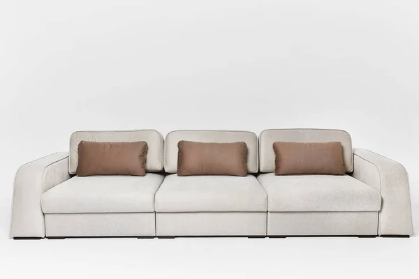 Sofá bege com três travesseiros castanhos em estilo moderno isolado no fundo branco — Fotografia de Stock
