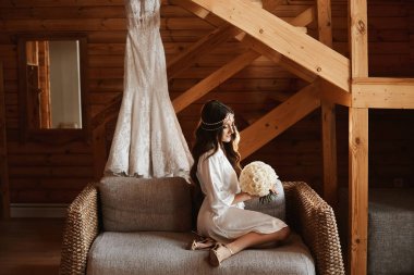 Elinde çiçek bir buket ile saten peignoir mükemmel bir vücut ile güzel genç model kadın