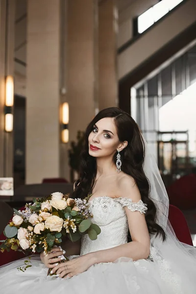 Mooie en sexy model vrouw in de modieuze trouwjurk houdt een boeket van verse bloemen — Stockfoto