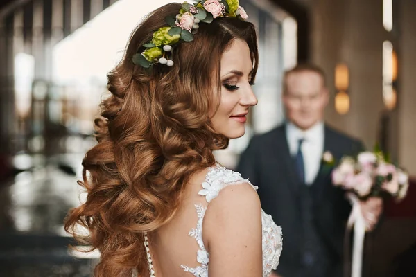 Bella e giovane donna modello bruna con trucco luminoso e con acconciatura elegante da sposa decorata con ghirlanda floreale — Foto Stock