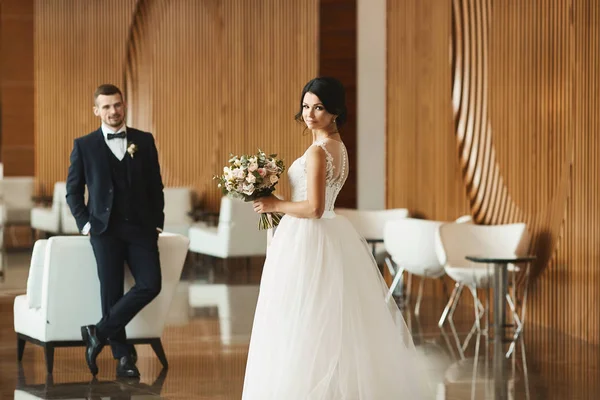 Braut im weißen Kleid hält Strauß in Händen — Stockfoto