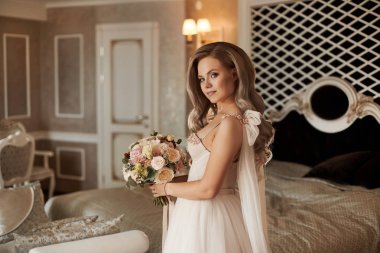 Güzel buket tutan fildişi elbise zarif genç gelin