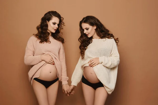 Front view of two similar pregnant woman in sweaters — Stock Photo, Image