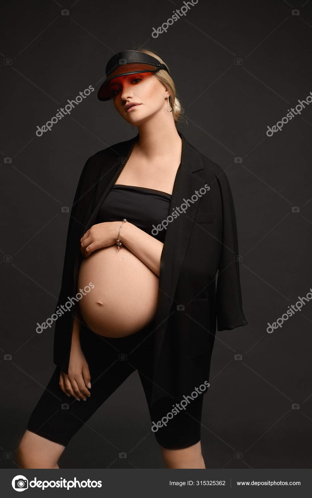 裸妊婦 暗い背景で裸の胃をポーズし、カメラを見て、隔離されたモディッシュブラックの衣装でハイファッションの若い妊婦。妊娠の先月のモデル女の子 — ストック写真  © innarevyako #315325362