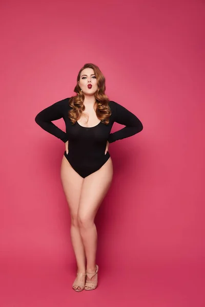 Plus Size Model Mädchen im schwarzen Body posiert auf rosa Hintergrund, isoliert. — Stockfoto