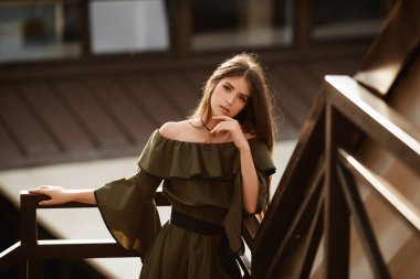 Yaz günü kentin arka planında poz veren yaz elbisesi giymiş genç bir manken kız..