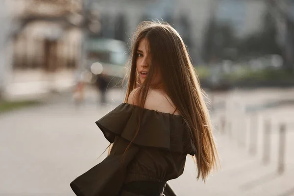 Portrét mladé modelky s tmavými vlasy v tmavozelených šatech na městské ulici — Stock fotografie