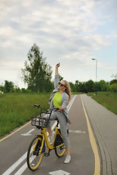 Chica modelo joven en traje de verano posando al aire libre con la bicicleta de color amarillo vintage, sonriendo y divertirse —  Fotos de Stock