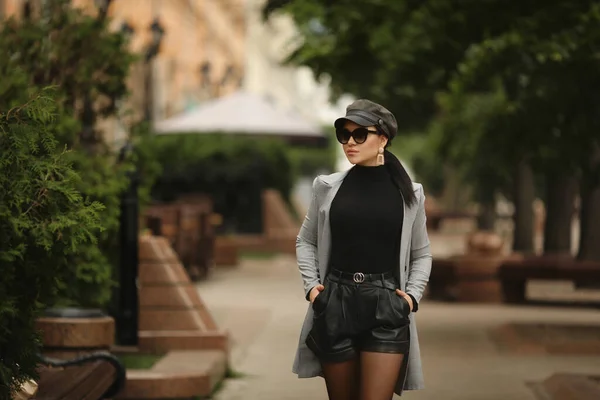 Eine junge Frau im Herbst-Outfit läuft in der europäischen Stadt am Bürgersteig entlang — Stockfoto