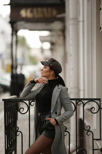 一个穿着时髦秋装的模特儿站在欧洲城市的大街上，从旁边看过去，等待着什么 — 图库照片