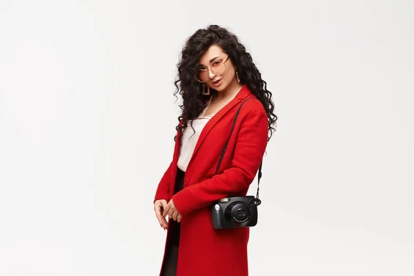 Модна елегантна жінка позує в червоному пальто і круглі сонцезахисні окуляри, ізольовані на білому . — стокове фото