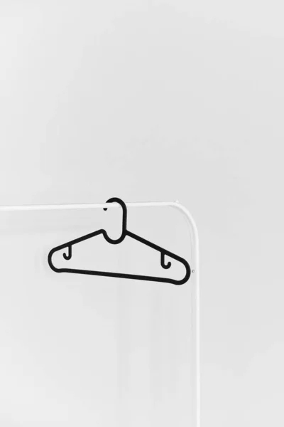 Black empty plastic hanger on the white rack isolated at the white background — Stock Photo, Image