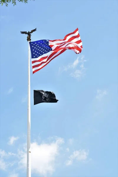 Bulutsuz bir günde Pow-Mia ve Amerikan bayrakları çırpınan