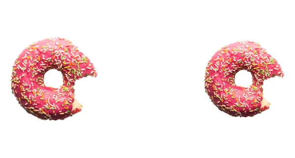 淡いピンクの背景にスプリンクルのついたピンク色のドーナツ 上からの給餌 — ストック写真