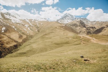 dağlar karlı zirveleri ve küçük turistler ve arabalar dağın altındaki Kafkasya