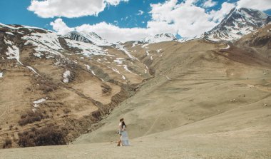 bir arka plan karlı yüksek dağlar ve gökyüzü üzerinde çift sarılma sevgi dolu