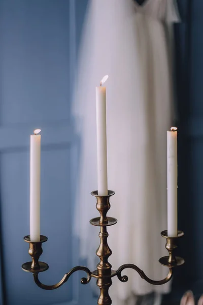 candelabra for three candles in the background white dress